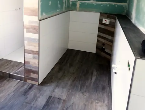 Vorwand mit Fliesen in Holzoptik neben der Dusche